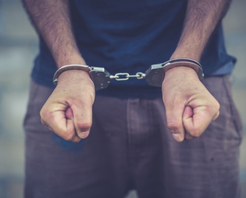 arrested-man-handcuffed-hands-back_2919-240